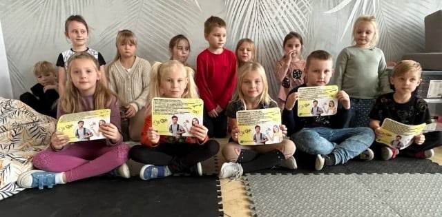 Dzieci w klasie trzymają plansze o cyberbezpieczeństwie