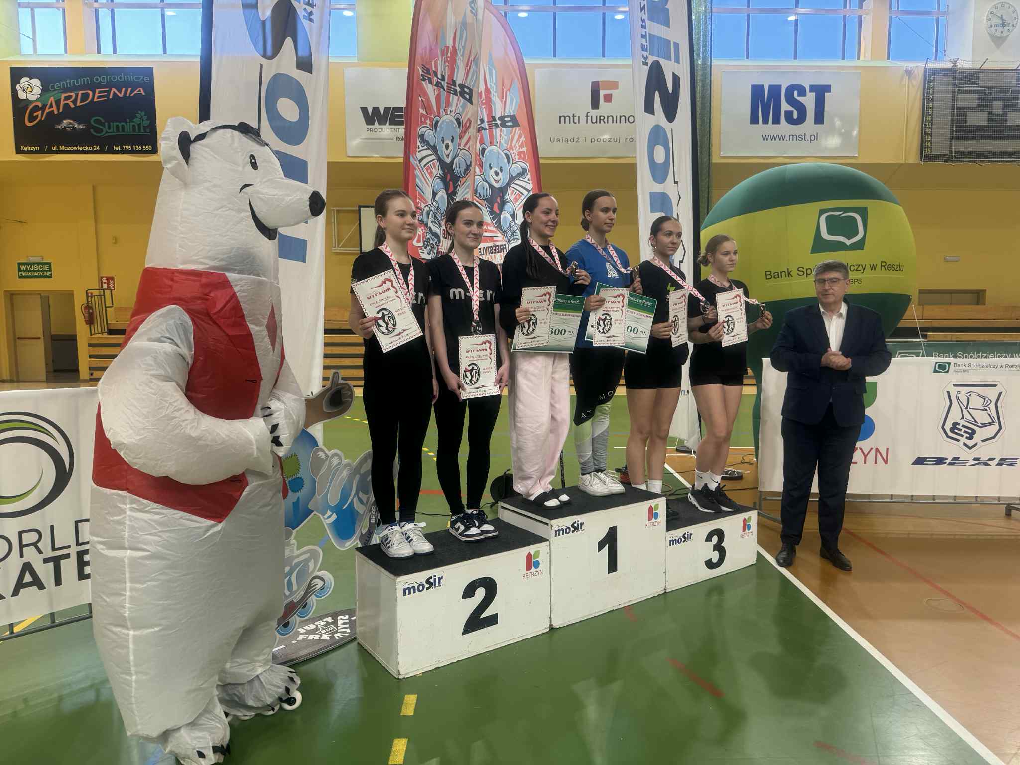 Dekoracja zwyciężczyń zawodów sportowych w hali MOSiR