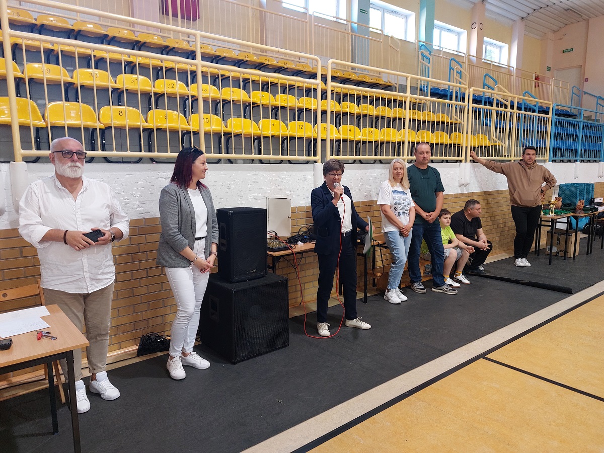 Organizatorzy i goście przy mównicy podczas zawodów sportowych
